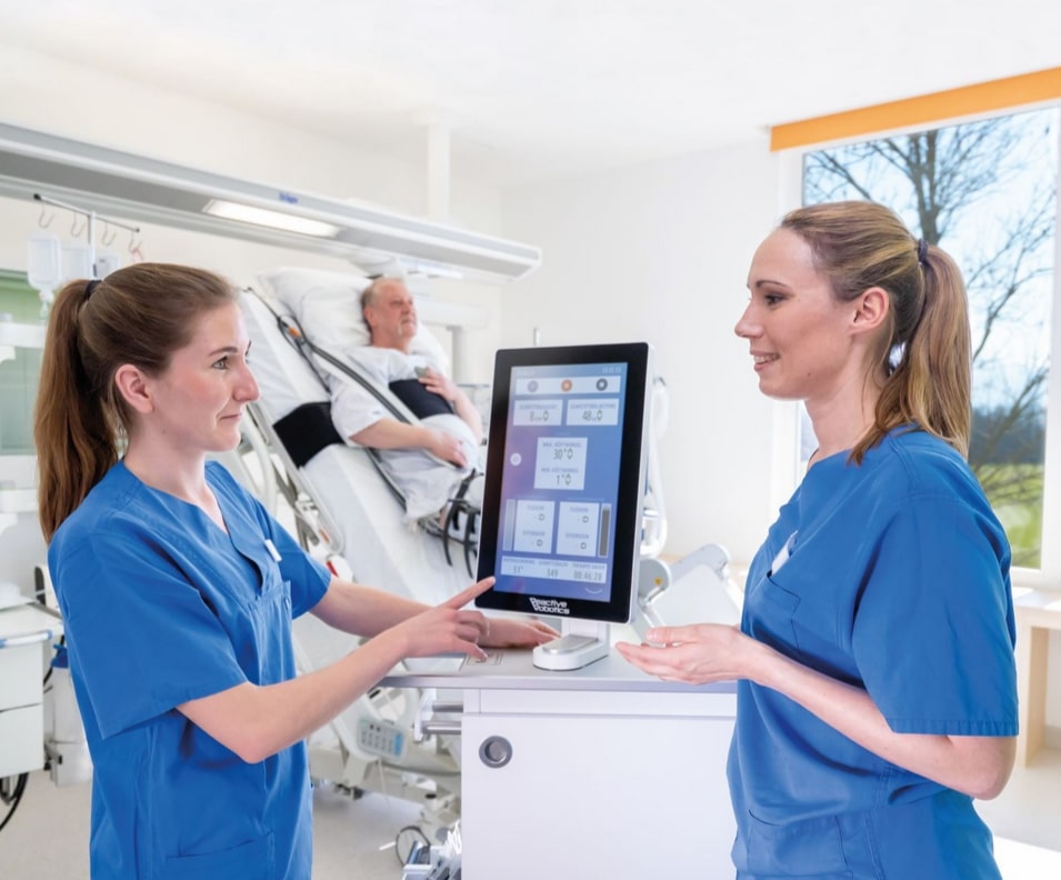 Zwei Krankenschwestern unterhalten sich - im HIntergrund steht der Monitor von Reactive Robotics